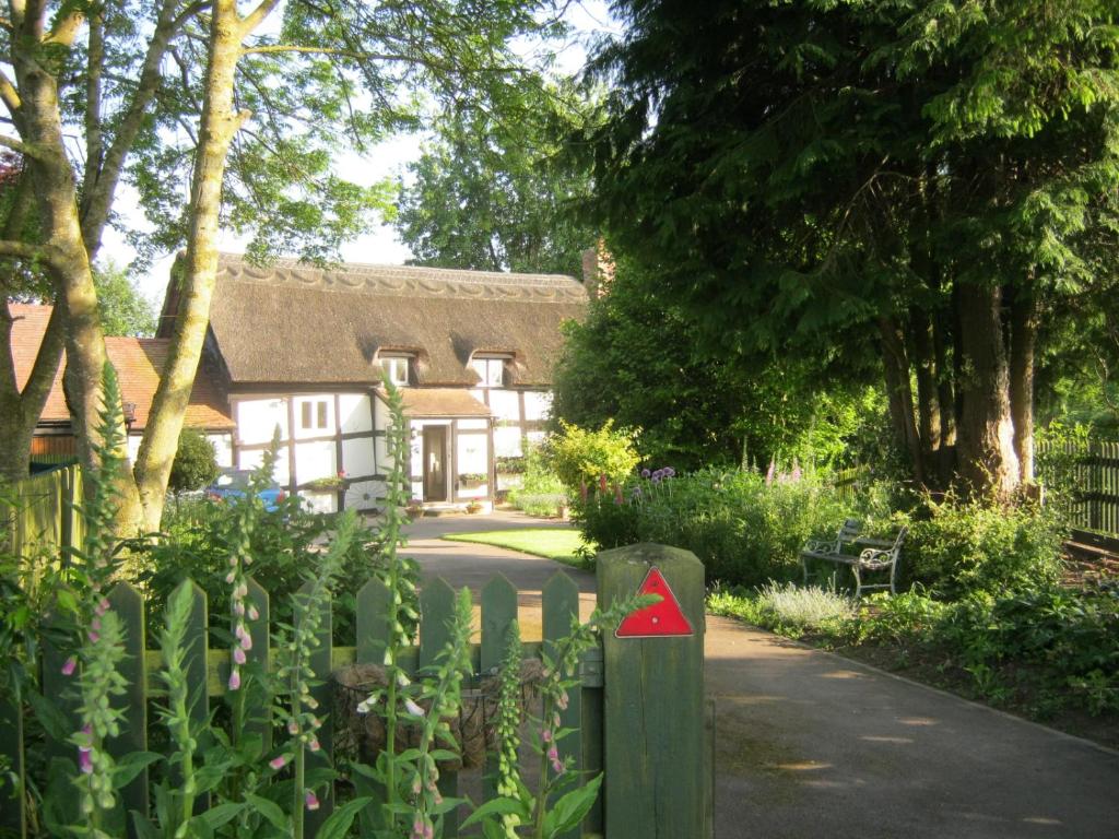 uma casa com uma cerca com um triângulo vermelho em The Moats - Ledbury em Ledbury