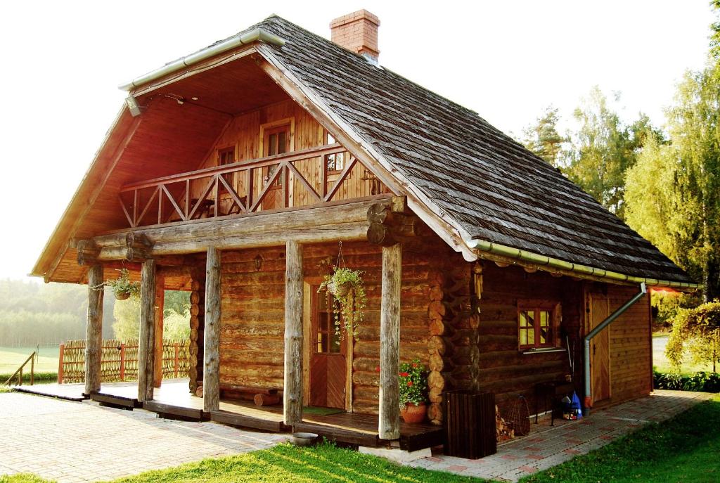 una cabaña de madera con techo de gambrel en Lejasbisenieki en Turaida