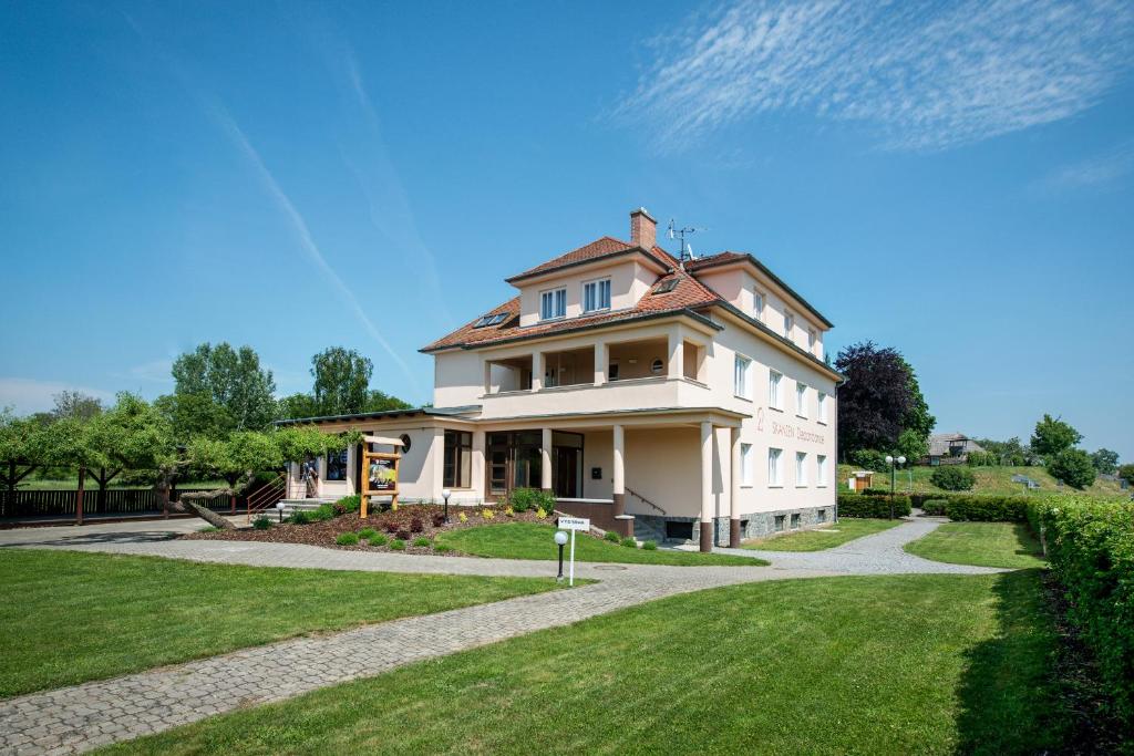 ヴェレフラトにあるHotel SKANZEN Depandanceの緑の芝生のある大白い家