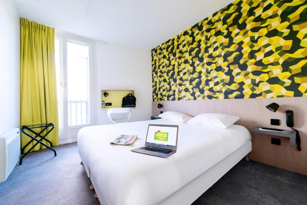 a hotel room with a bed with a laptop on it at The Originals City, Ara Hôtel, Landerneau in Landerneau