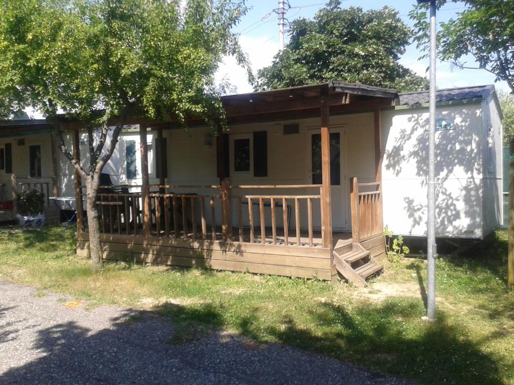 uma pequena casa com um alpendre e um deque em Campeggio Amici di Lazise em Lazise