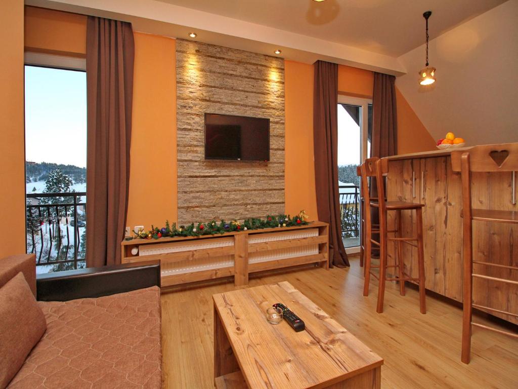 a living room with orange walls and a flat screen tv at Apartments Stojic in Zlatibor