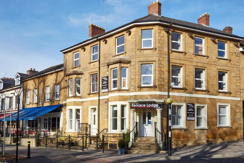 a large brick building on the corner of a street at The Terrace Lodge Hotel in Yeovil