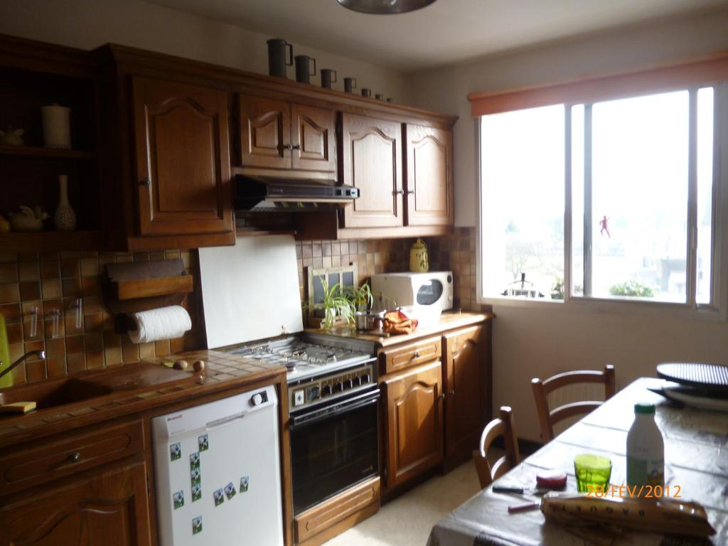 a kitchen with wooden cabinets and a stove top oven at L&#39;appartement du Haut Plessis in Blois