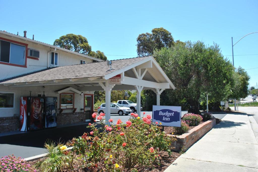 a building with a sign that reads quick inn at Budget Inn in San Luis Obispo