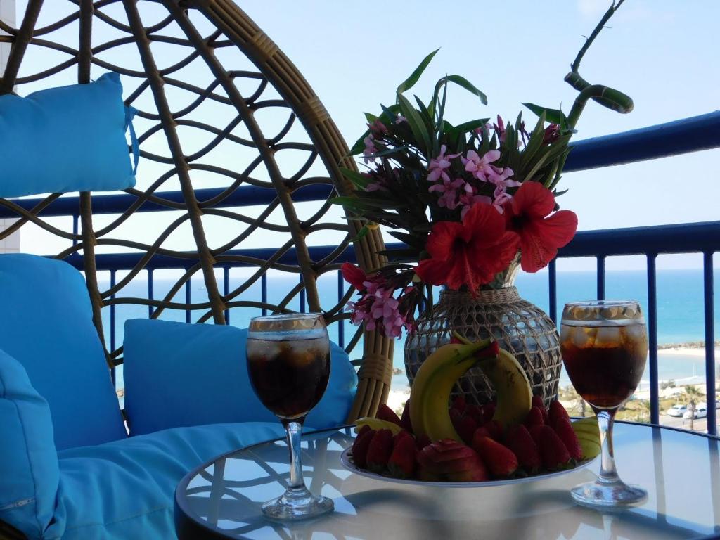 un tavolo con due bicchieri di vino e un piatto di frutta di Sunrise Apartment ad Ashkelon