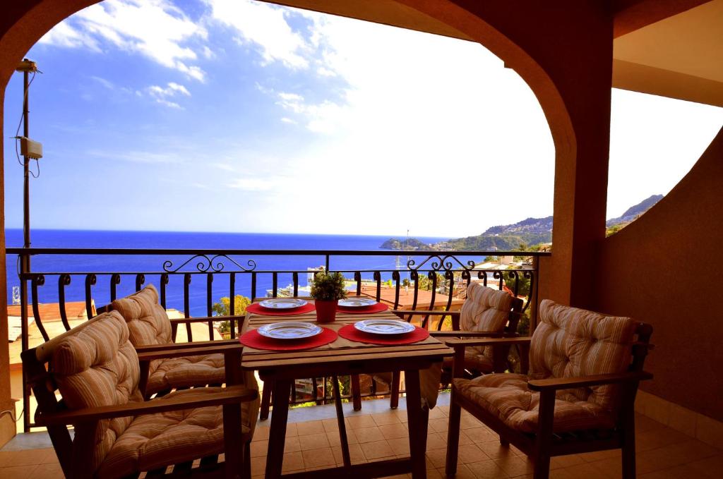 a table on a balcony with a view of the ocean at Casa Antonella in Letojanni