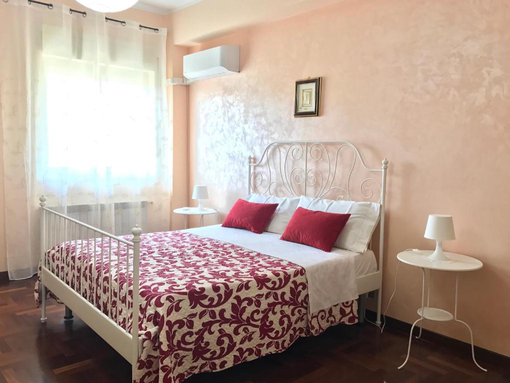Un dormitorio con una cama con almohadas rojas y una ventana. en Isola 92100, en Agrigento