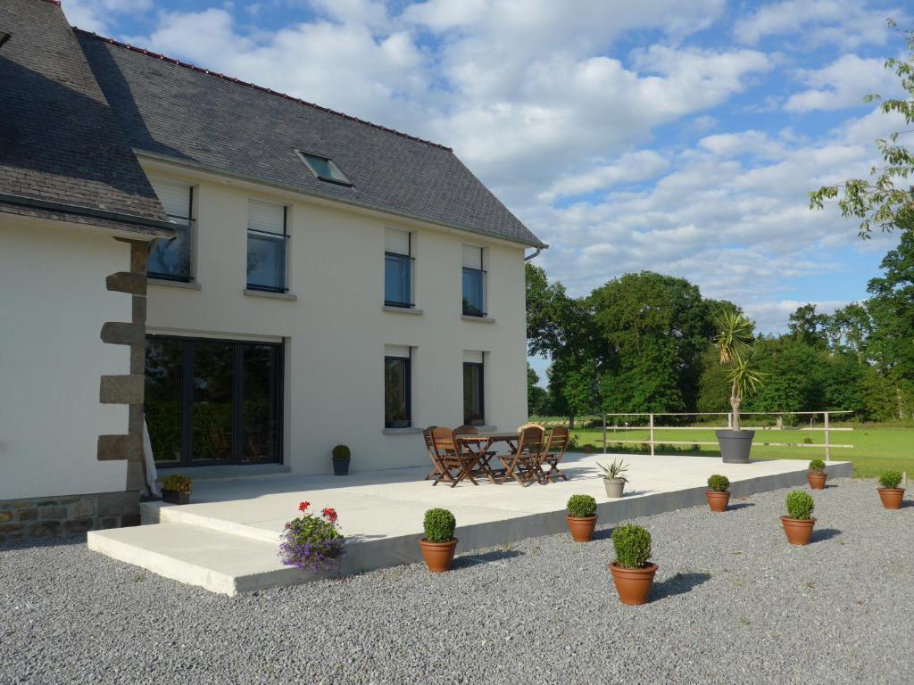 ein weißes Haus mit Topfpflanzen davor in der Unterkunft Maison de Luciné in Combourg