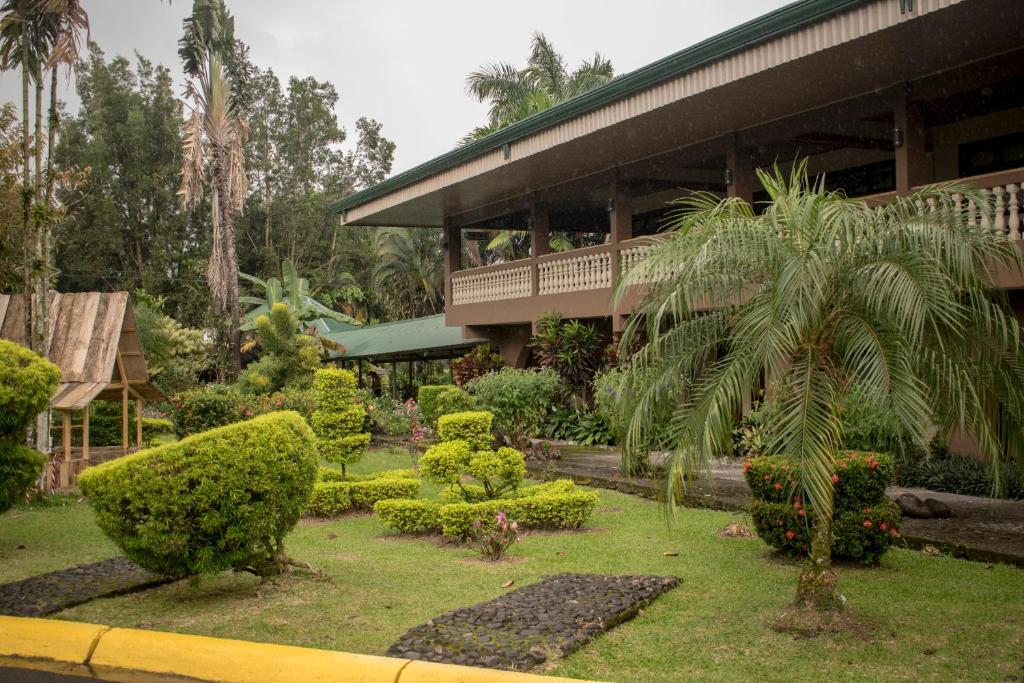 ogród z palmą przed budynkiem w obiekcie Hotel Suerre w mieście Guápiles