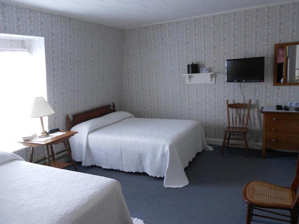 a hotel room with two beds and a television at Shaw's Hotel & Cottages in Brackley Beach