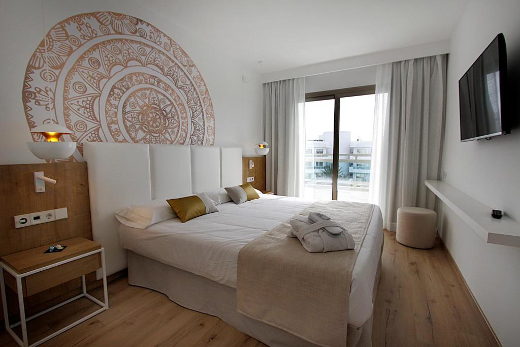 1 dormitorio con 1 cama grande y TV en BG Rei del Mediterrani en Playa de Muro