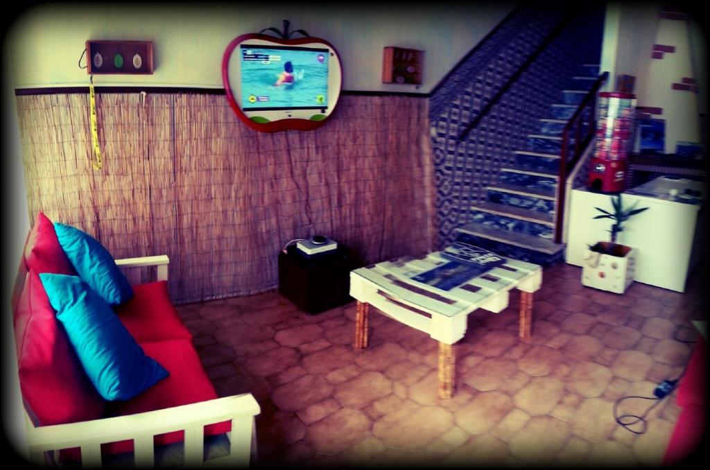 a living room with a couch and a tv at SwordFish Eco-House Peniche in Peniche