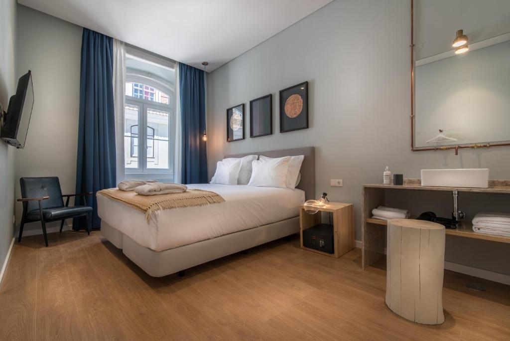 a bedroom with a bed and a desk and a mirror at Esqina Urban Lodge in Lisbon