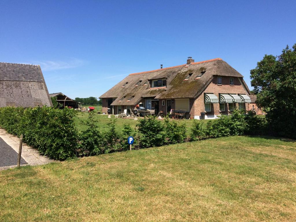 a large house with a roof with a yard at B&B op Wijngoed Havelte in Havelte