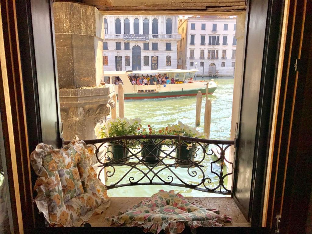une fenêtre avec vue sur un bateau dans l'eau dans l'établissement La Felice Canal Grande, à Venise