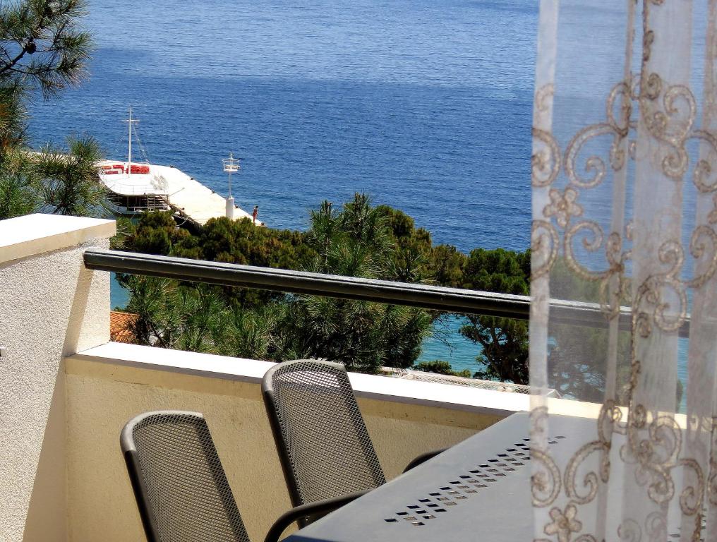a balcony with a table and chairs and the ocean at Apartments Staničić in Brela