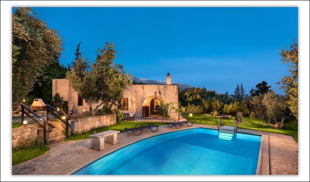 a swimming pool in front of a stone building at Villa Aloni in Fílippos