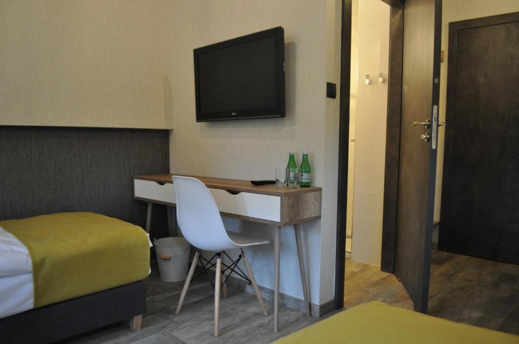 Zimmer mit einem Schreibtisch, einem TV und einem Bett in der Unterkunft Pokoje Zimna Woda in Rozalin