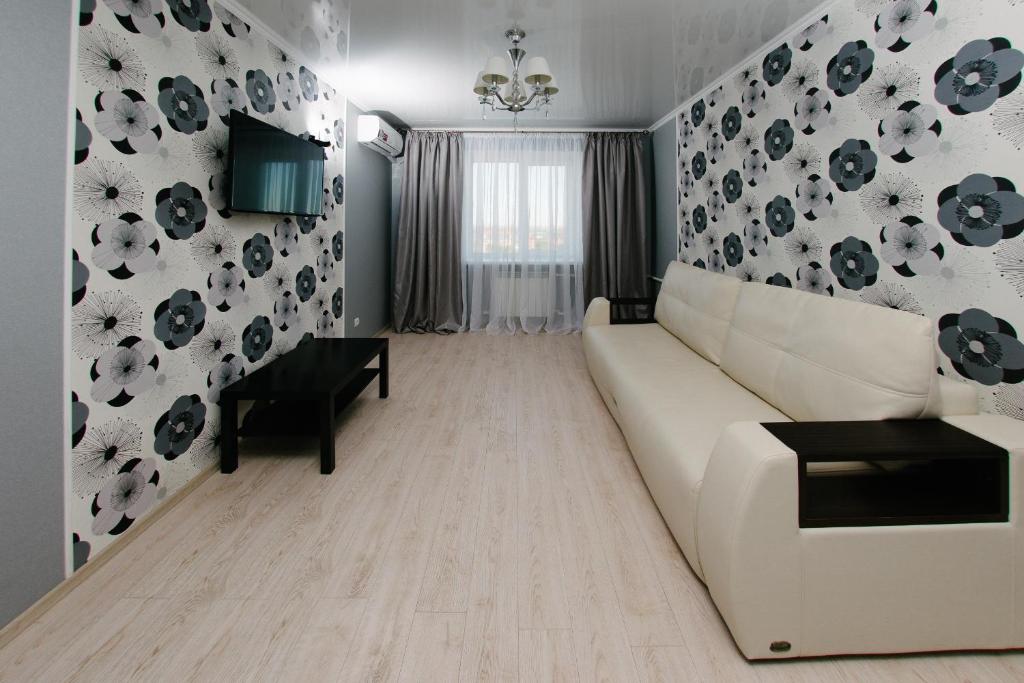 a living room with a white couch and a table at City Center Apartment on Pochtovy 4 in Orenburg