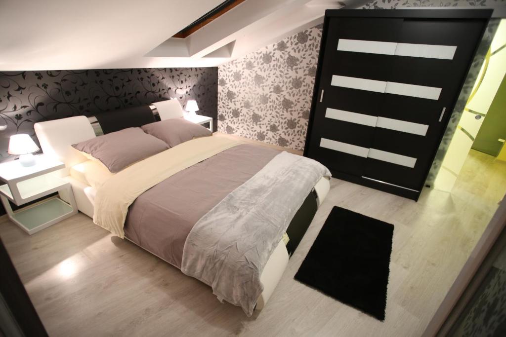 um quarto com uma cama grande num quarto em Centrum Lux Apartman em Kaposvár