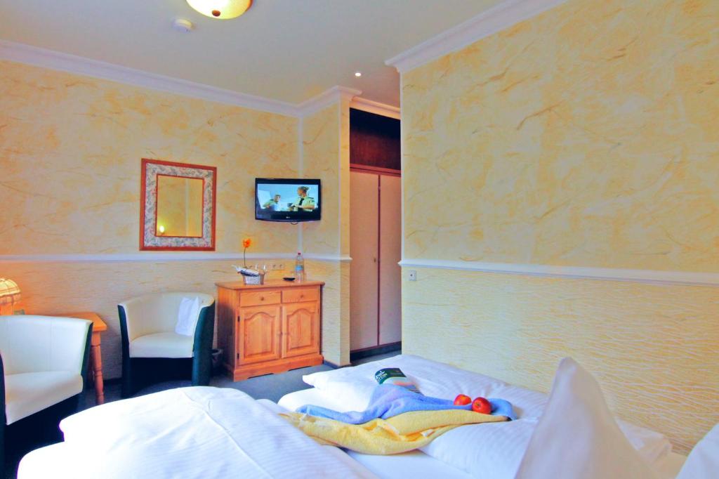 ein Schlafzimmer mit einem Bett mit einem Kind auf dem Bett in der Unterkunft Hotel Weingärtner in Bad Wildbad