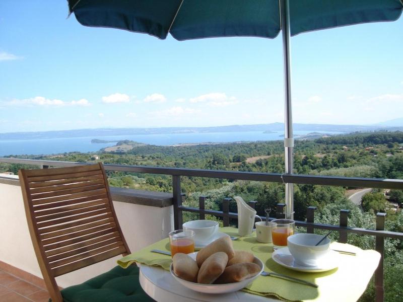 einen Tisch mit einem Teller Essen auf dem Balkon in der Unterkunft Il Bellago in Valentano