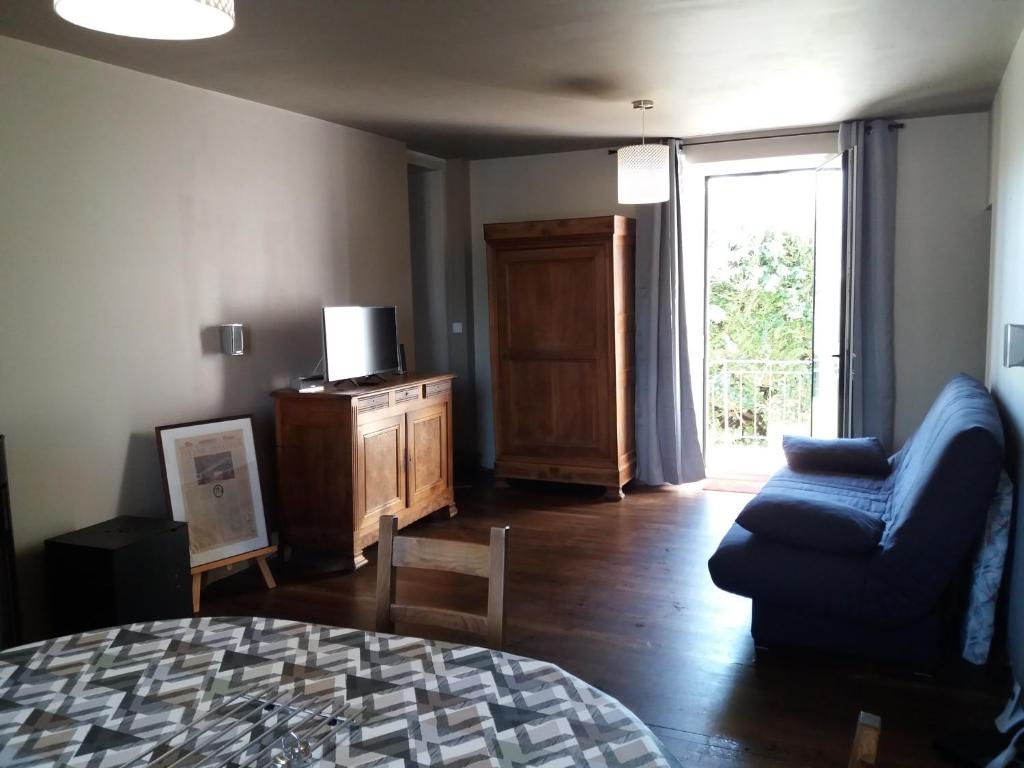 un salon avec un canapé bleu et une fenêtre dans l'établissement Maison de Vacances, à Châteaumur