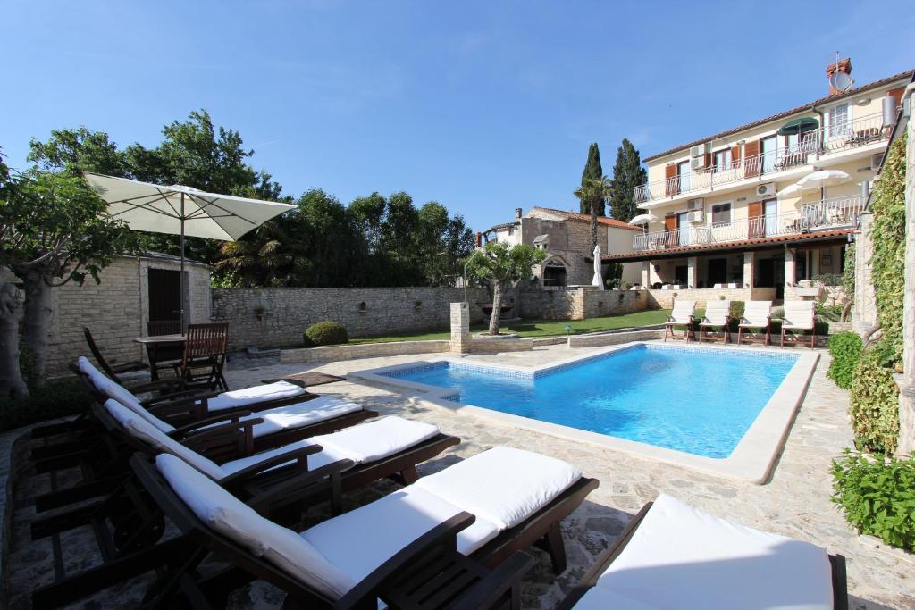 una piscina con tumbonas y un edificio en B&B Villa Velike Stine, en Medulin