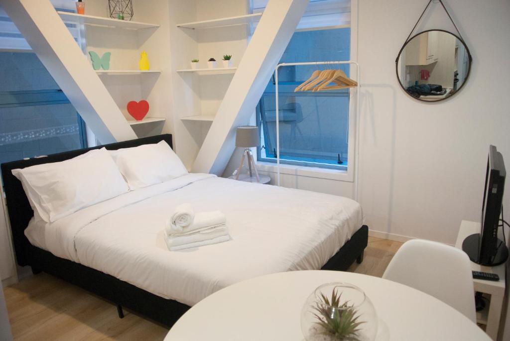 een slaapkamer met een bed, twee tafels en een raam bij Snug Studio in the heart of the city in Auckland
