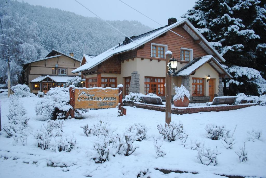 ein Haus mit einem Schild im Schnee in der Unterkunft Complejo Aspen in San Martín de los Andes