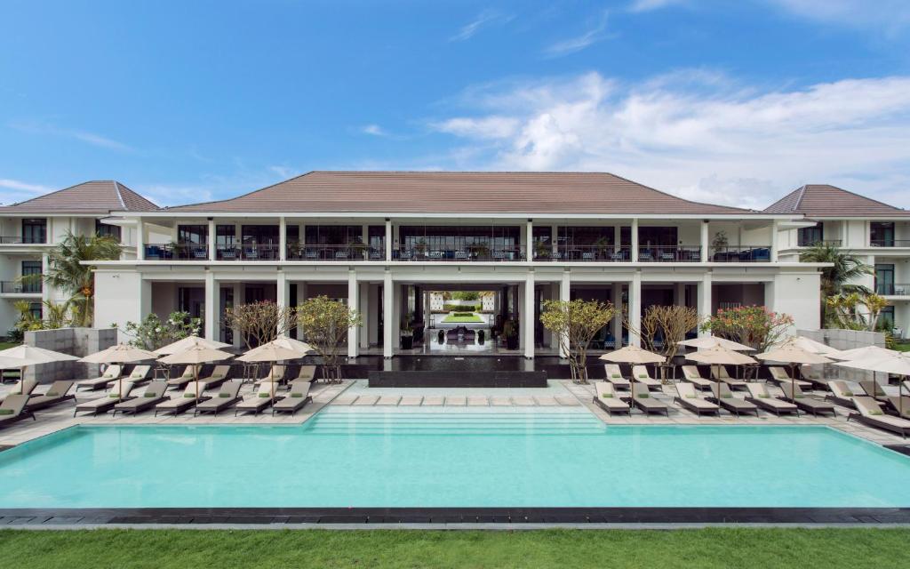 ein Resort mit einem Pool und Stühlen sowie einem Gebäude in der Unterkunft U Sathorn Bangkok in Bangkok