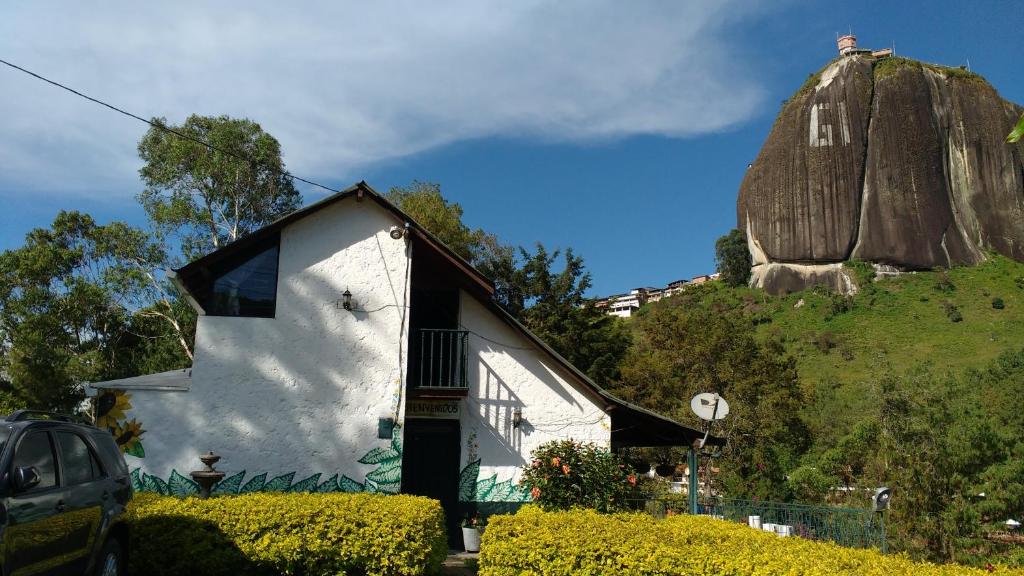 a white house with a rock in the background at Las Cabañas Castillos del Lago in Guatapé