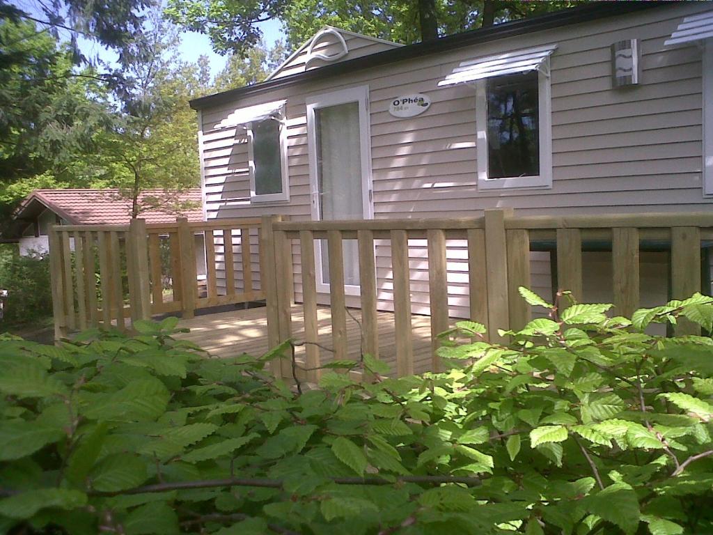 une clôture en bois devant une maison dans l'établissement Camping Hurongues, à Pomeys