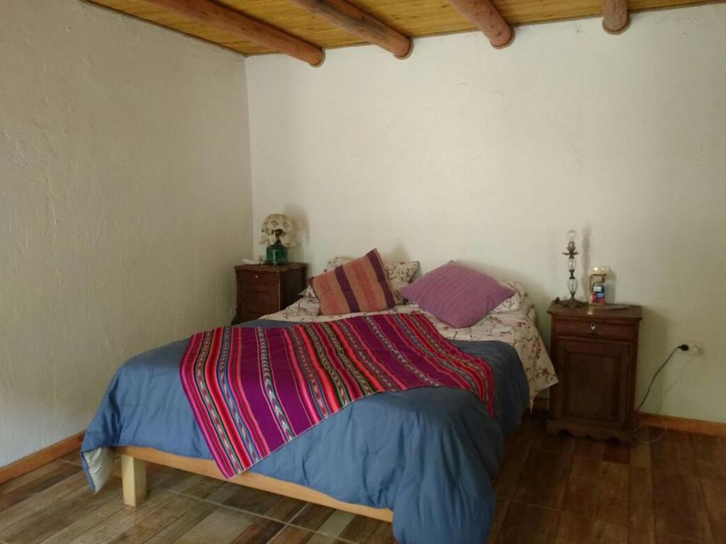 a bedroom with a bed with a colorful blanket on it at Posada la Piedra in Constitución