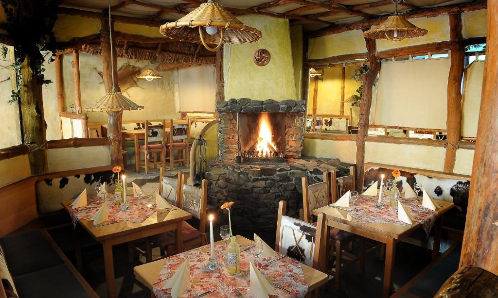 a restaurant with two tables and a fireplace at Kelten-Hotel in Sünna