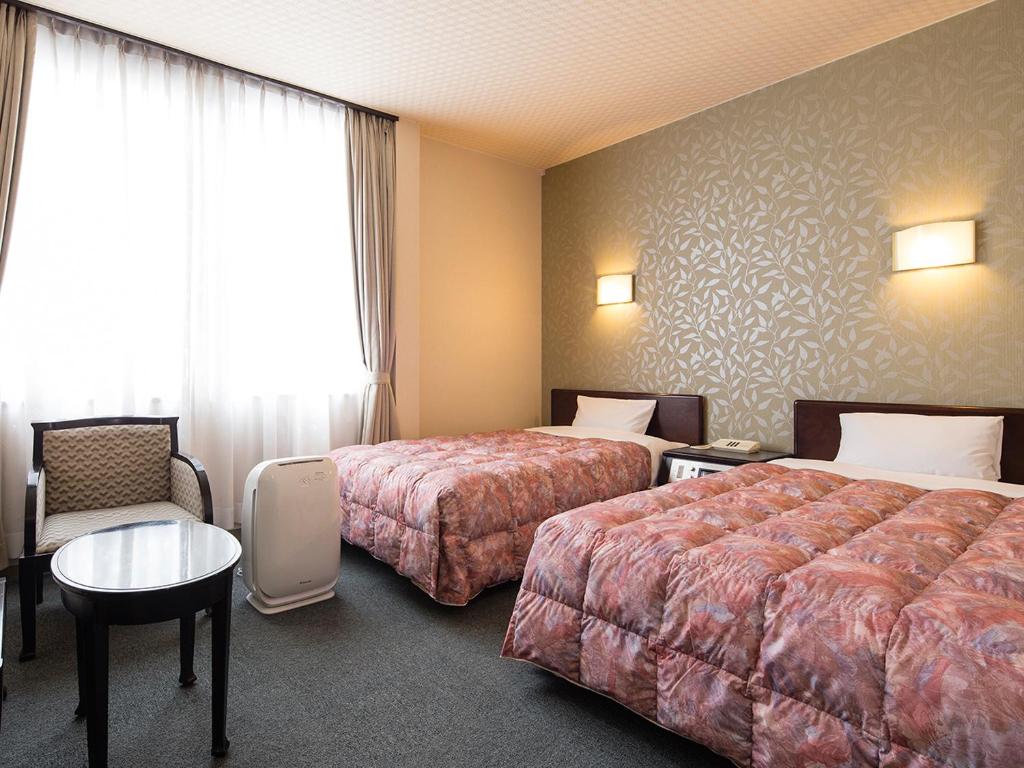 Postel nebo postele na pokoji v ubytování Kotohira Riverside Hotel