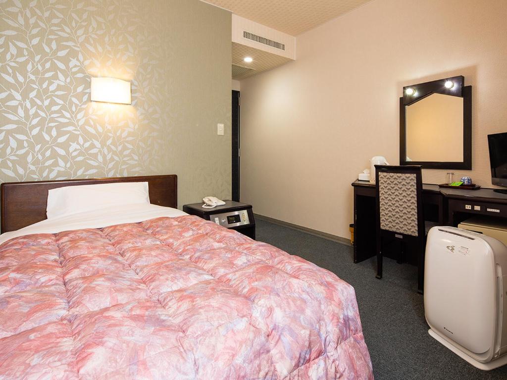 Postel nebo postele na pokoji v ubytování Kotohira Riverside Hotel