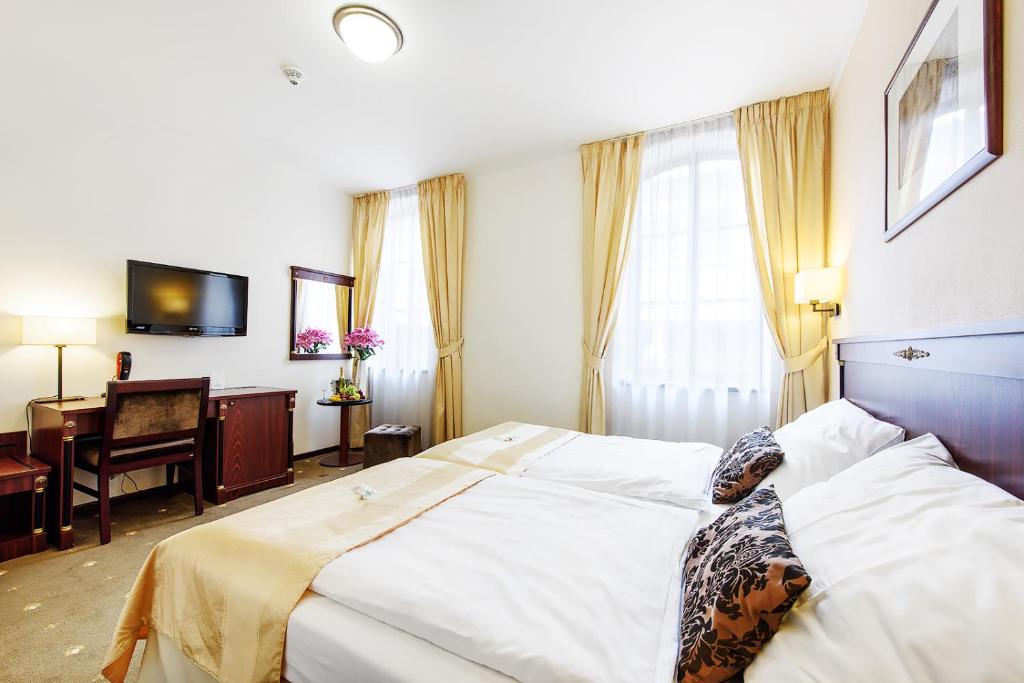 Postel nebo postele na pokoji v ubytování Hotel & Apartments U Černého orla