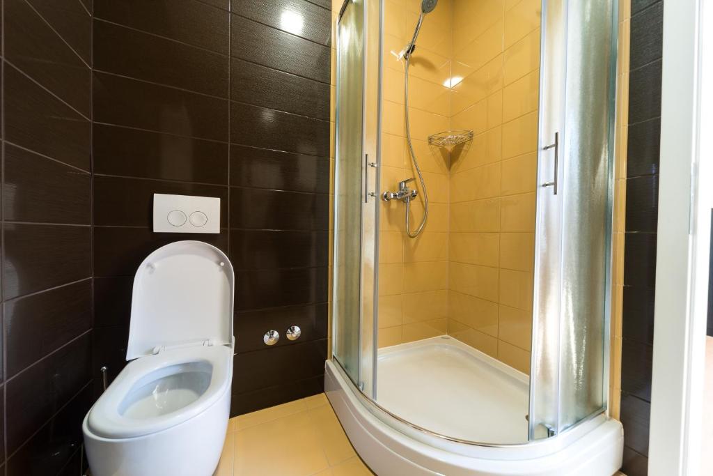 a bathroom with a toilet and a shower at Villa Gradski Vrt in Osijek