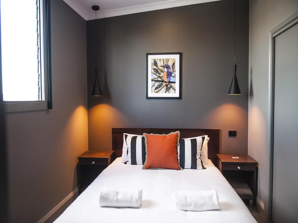 1 dormitorio con 1 cama grande con almohadas de color naranja en Criterion Hotel Sale, en Sale