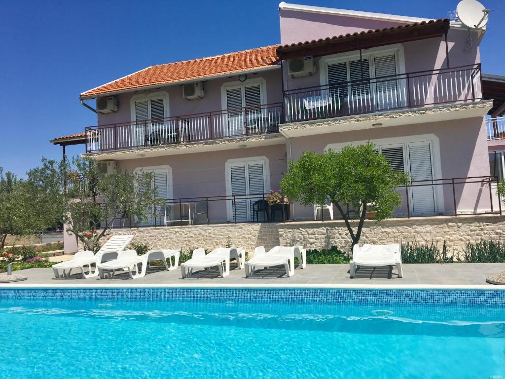 a villa with a swimming pool in front of a house at KrkaHaus in Lozovac