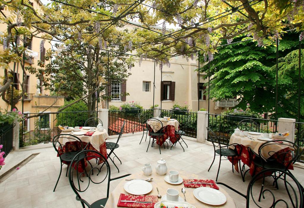 eine Terrasse mit Tischen und Stühlen im Innenhof in der Unterkunft Ca' San Rocco in Venedig