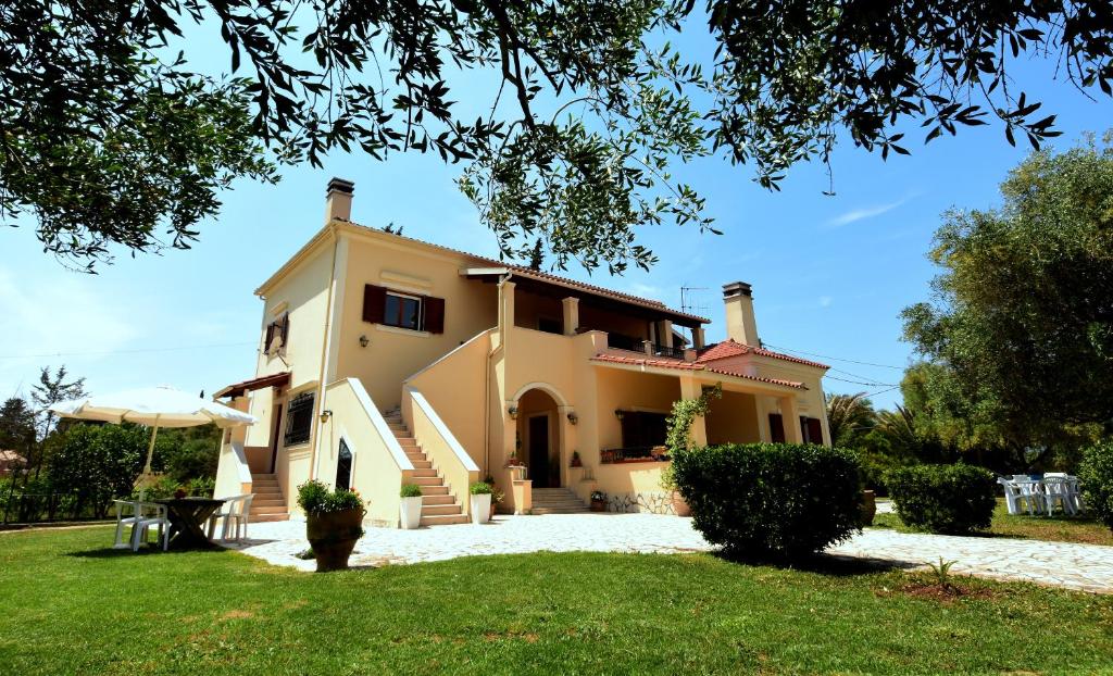 uma casa grande com um relvado em frente em Villa Rose Garden em Ágios Ioánnis