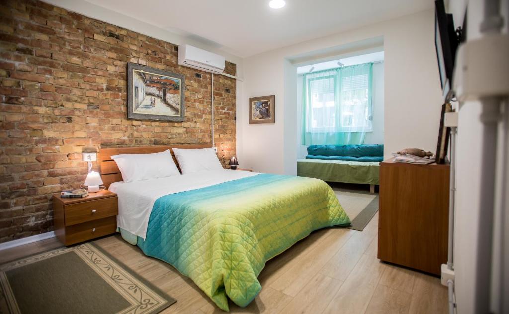 sypialnia z łóżkiem i ceglaną ścianą w obiekcie B&B Artistic Tirana w Tiranie