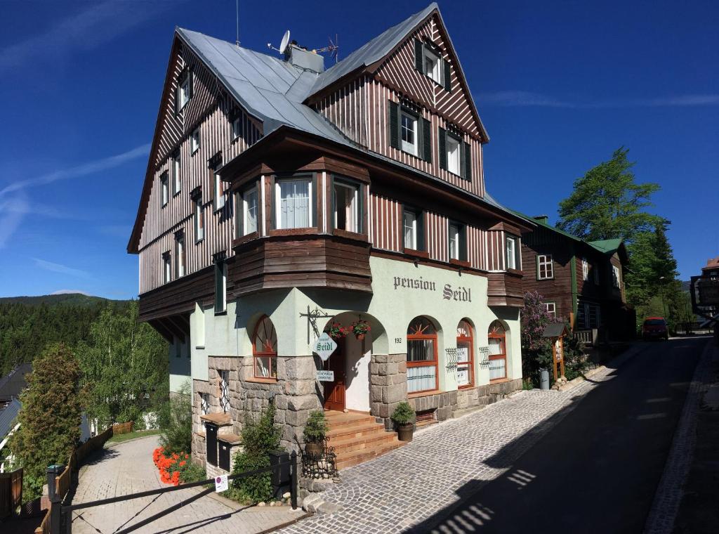 uma casa grande com um telhado de gambrel em Pension Seidl em Spindleruv Mlyn