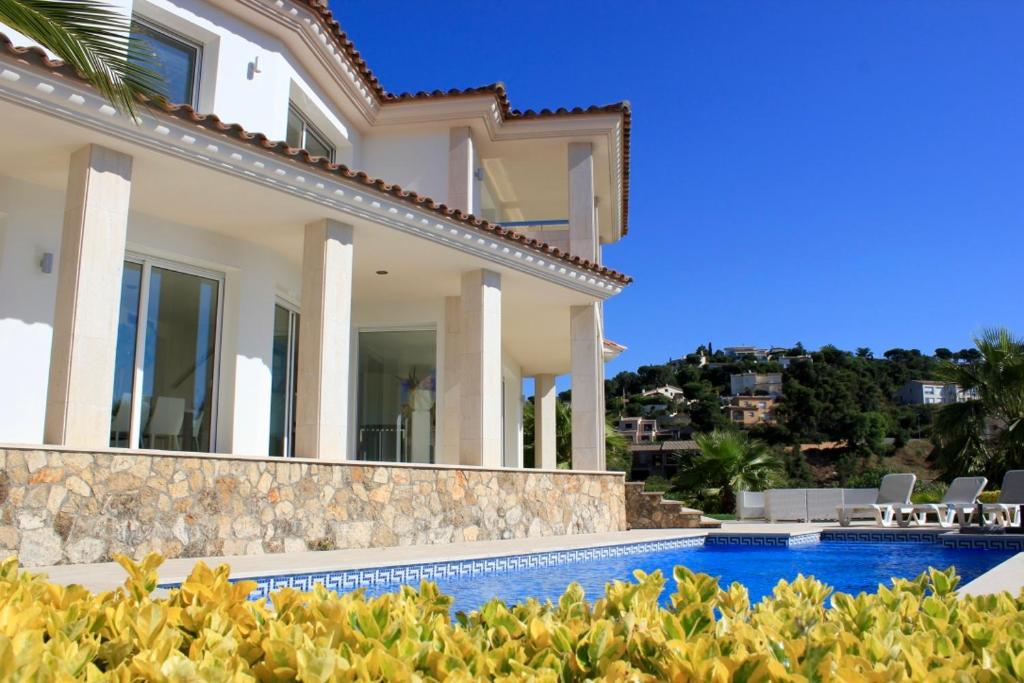 a villa with a swimming pool and a house at Villa De Oro in Calonge