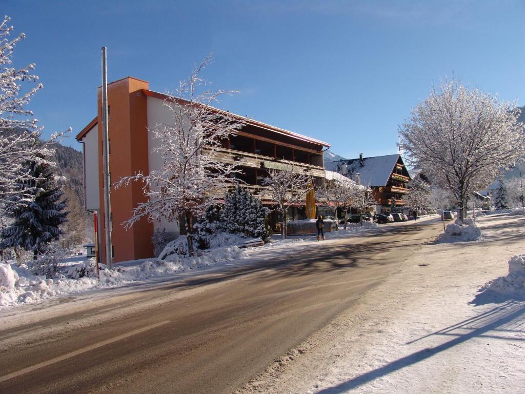 a street with snow covered trees and a building at Gasthof Stern in Vandans