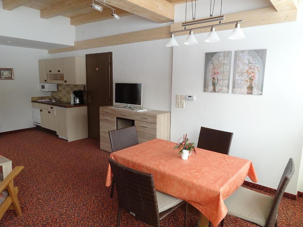 エールヴァルトにあるAppartements Loisachpromenadeのテーブルと椅子、キッチンが備わる客室です。