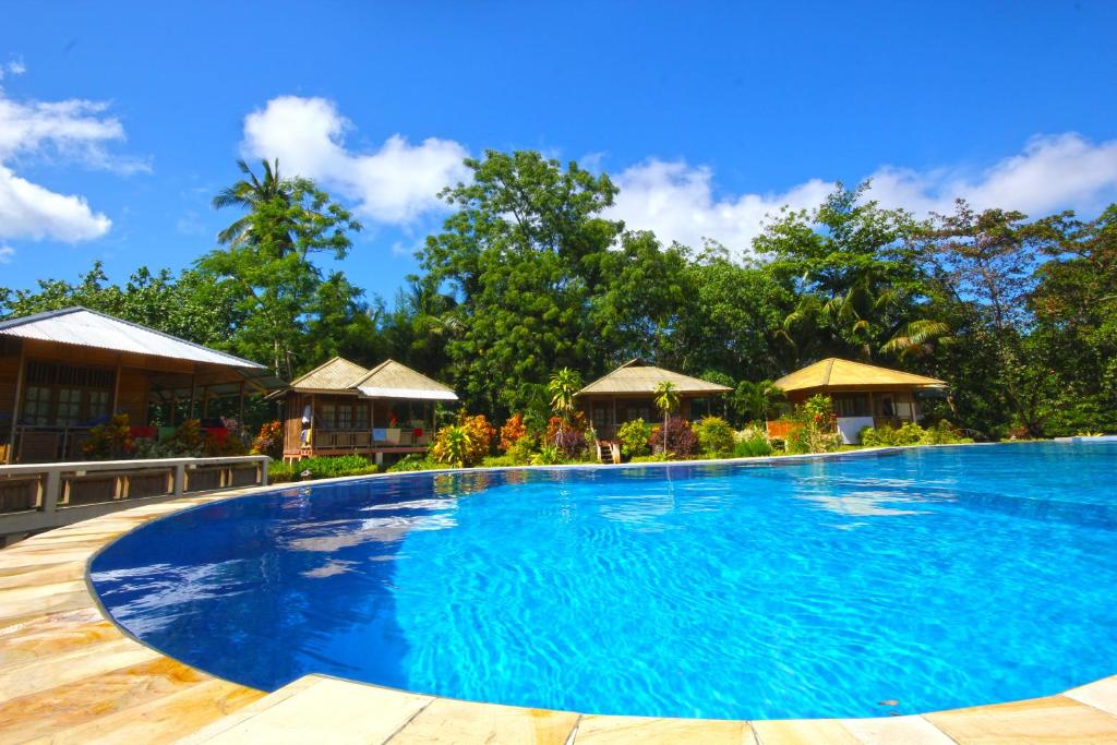 a large swimming pool in front of a resort at Two Fish Resort Bunaken in Bunaken